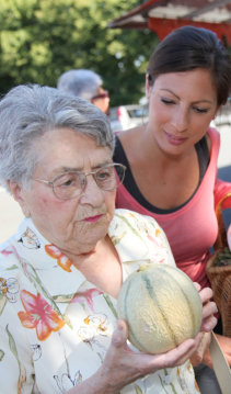 caregiver assisting an old woman in a grocery