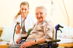 nurse checking blood pressure of old woman